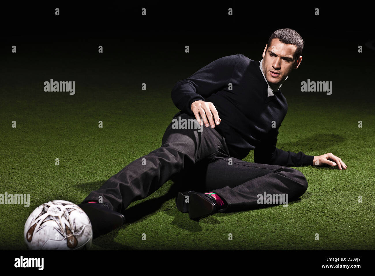 Fußballer für Ball auf Kunstrasen zu erreichen Stockfoto
