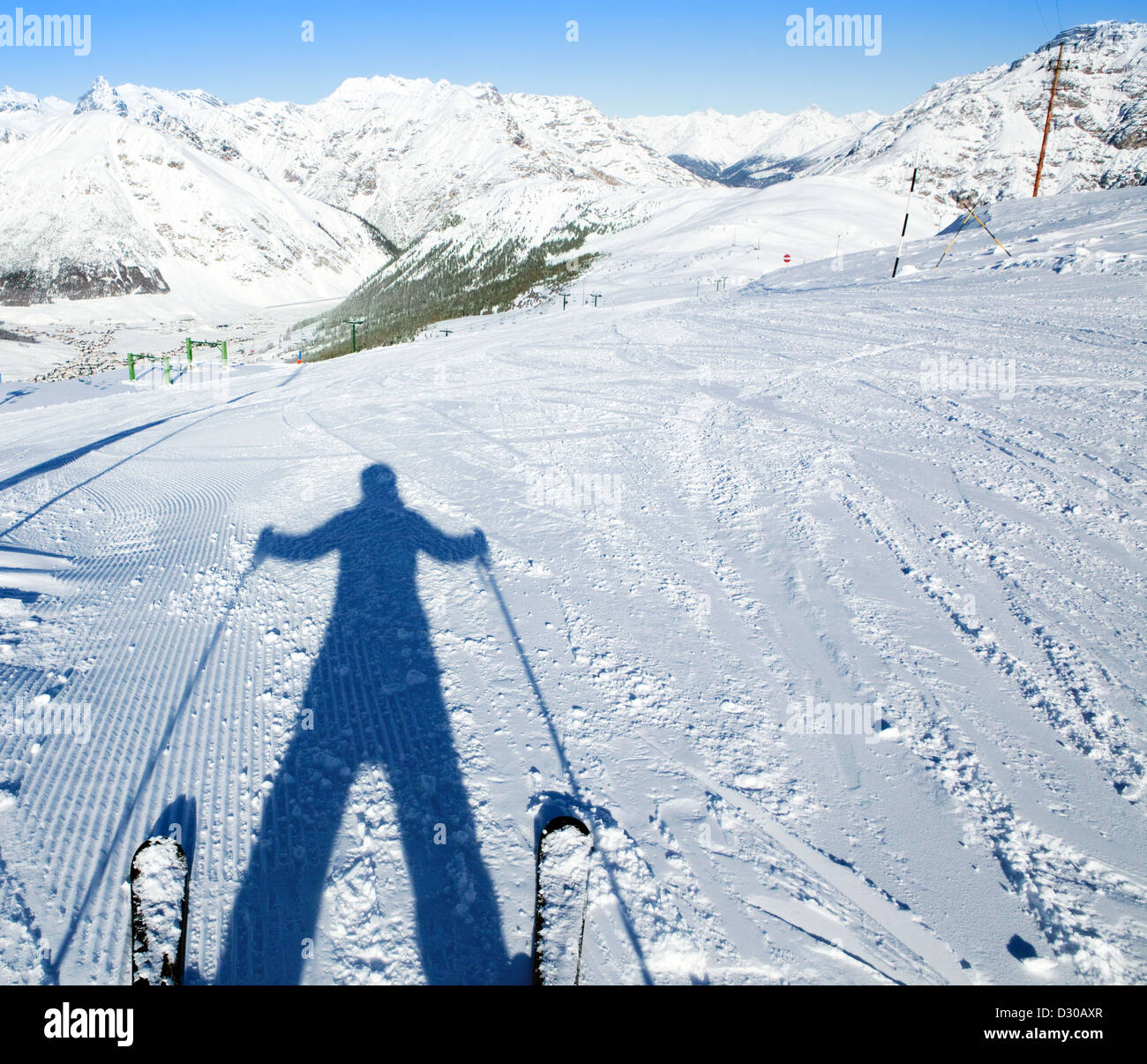 Skifahrer Schatten und frische Schnee Kurven unter die Skier, Ski Piste und Berge Panorama in der Morgensonne Stockfoto