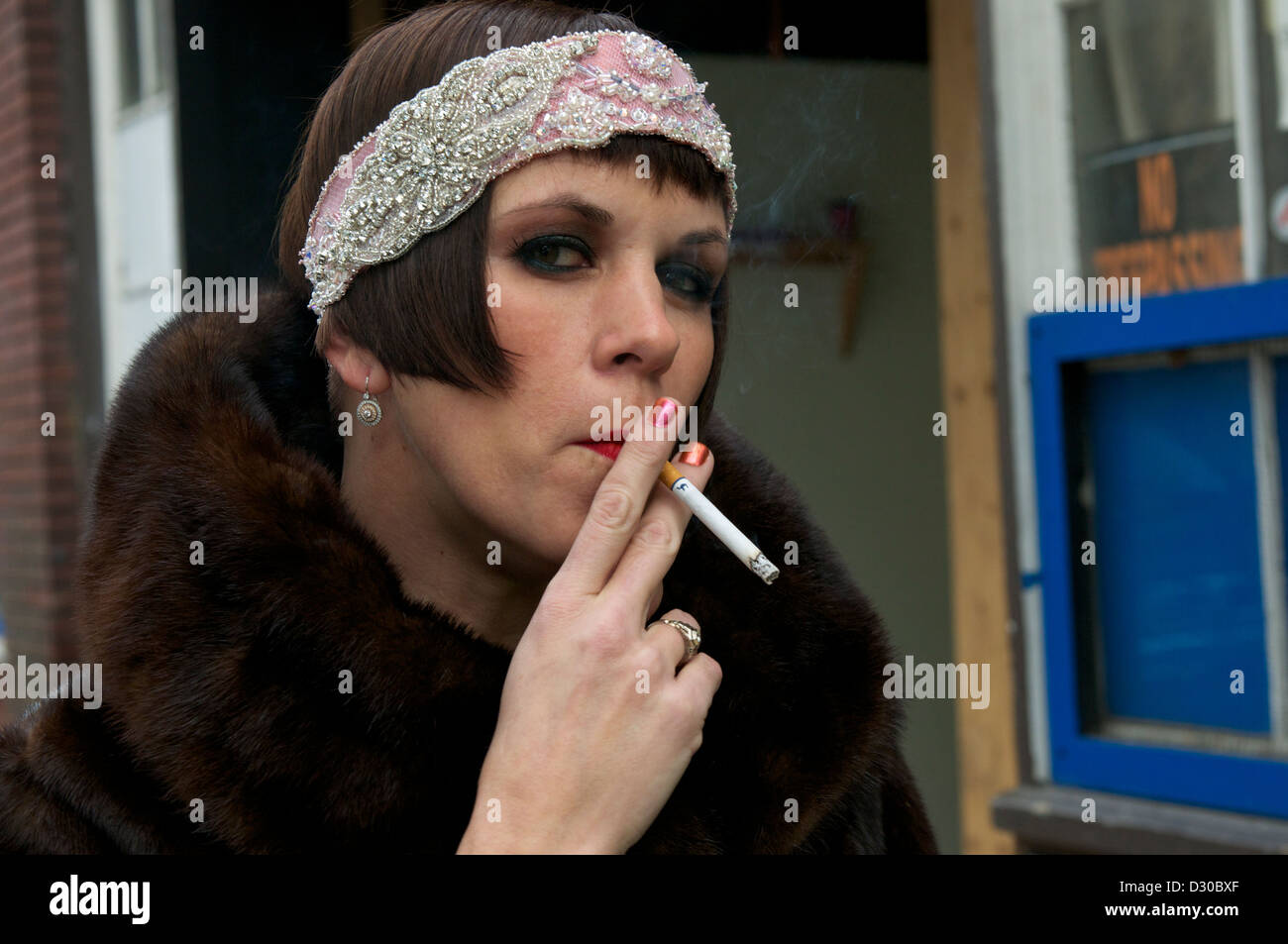 Retro-chic Frau Rauchen auf einer Stadtstraße im Pelzmantel Stockfoto