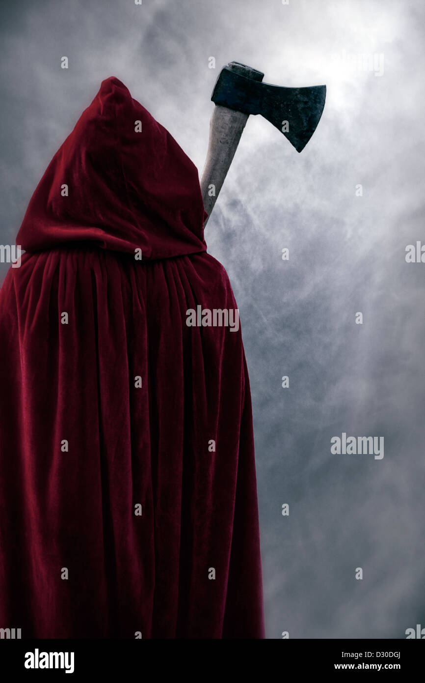 eine Gestalt in einem roten Mantel mit einer Axt Stockfoto