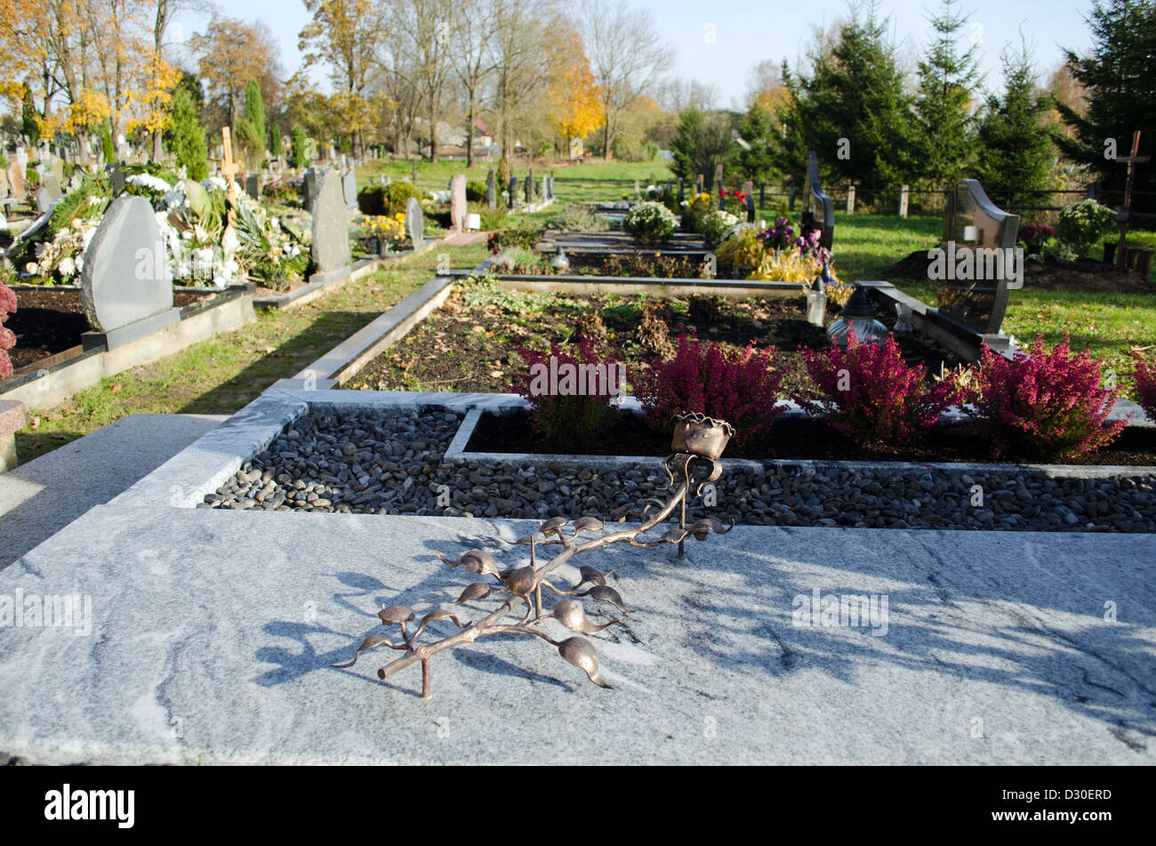 Kupfer Messing künstliche rose auf ländlichen Friedhof Grab Grab und viele Grabsteine Denkmäler im Herbst Friedhof. Stockfoto