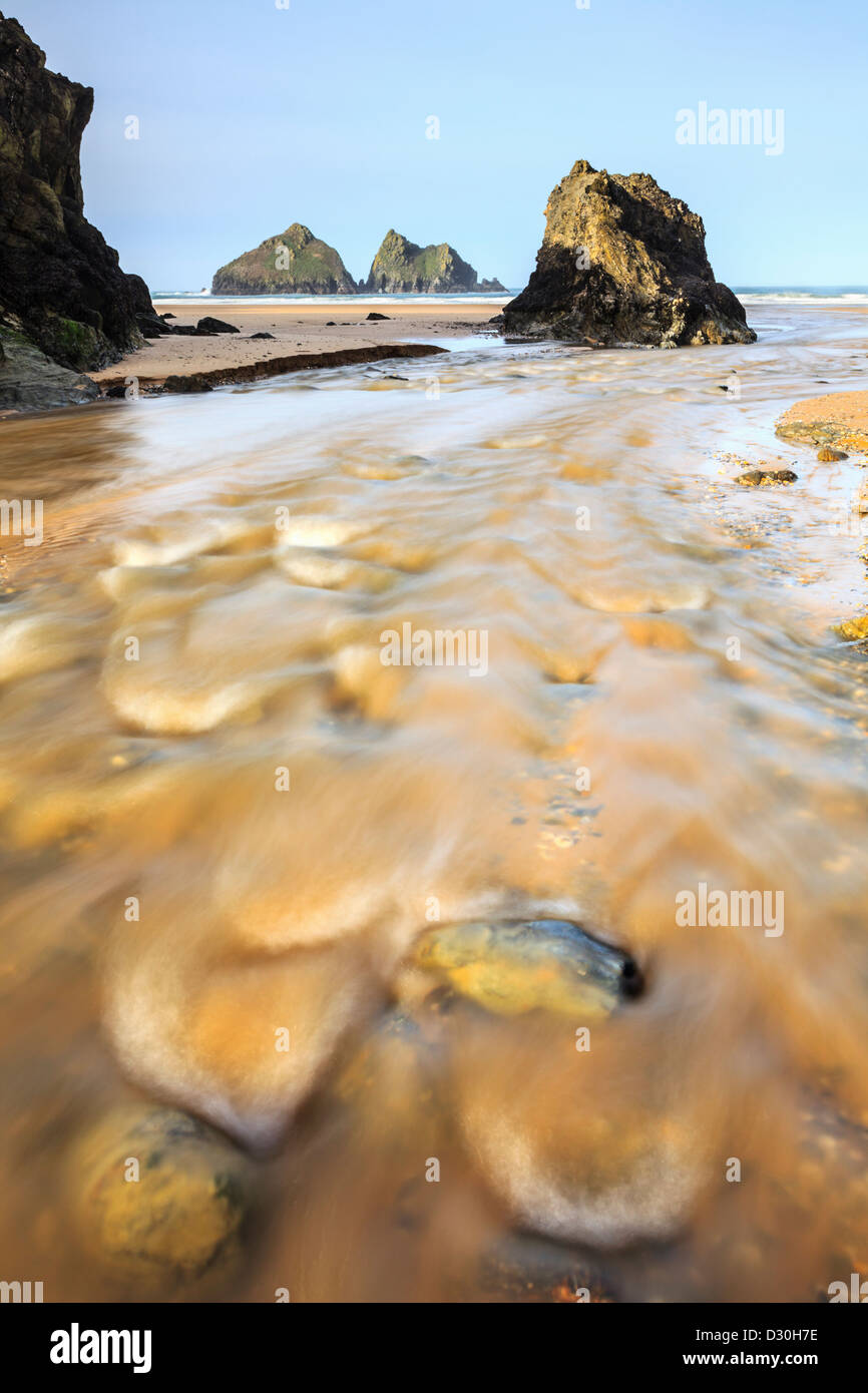 Der Fluss am Holywell Bay Beach, gefangen genommen, nachdem ein Zauber von nassem Wetter eine längere Verschlusszeit verwenden, um das Wasser zu verwischen Stockfoto