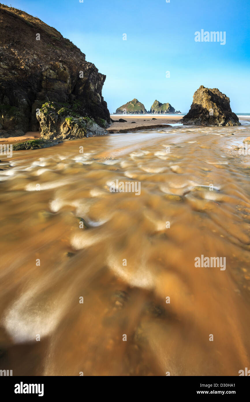 Der Fluss am Holywell Bay Beach, gefangen genommen, nachdem ein Zauber von nassem Wetter eine längere Verschlusszeit verwenden, um das Wasser zu verwischen Stockfoto