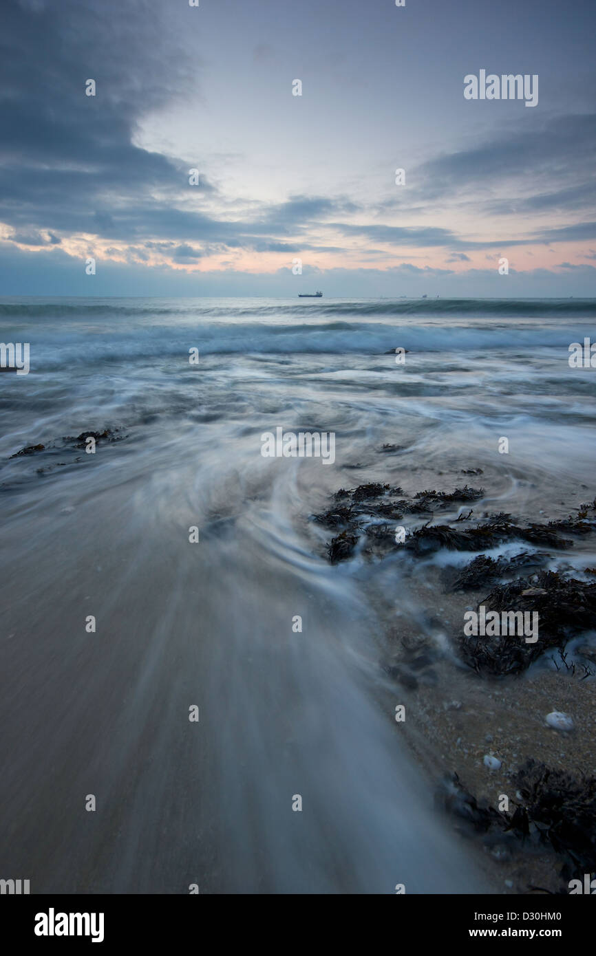 Welle rauschenden zurück zum Meer am Strand von Burg in Falmouth bei Sonnenaufgang Stockfoto