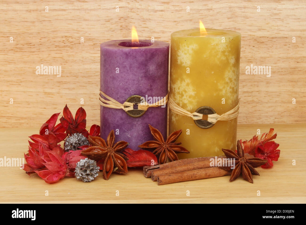Zwei brennende Feng Shui Kerze, Potpourri, Zimt und Sternanis aus Holz im Hintergrund Stockfoto