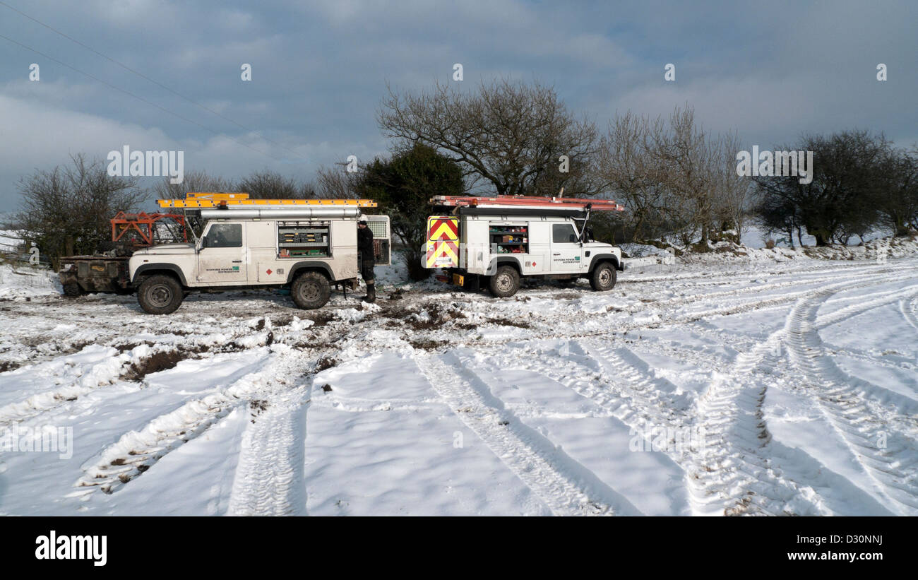 Western Power Distribution Fahrzeuge in schneebedeckten Feld auf Farm land Wales UK Stockfoto