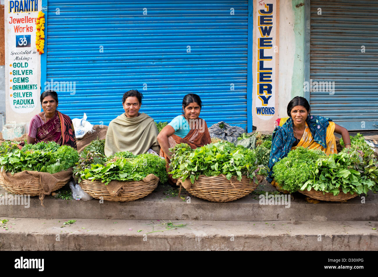 Indische Frauen Kräuter und Blattgemüse aus Körben zu verkaufen. Puttaparthi, Andhra Pradesh, Indien Stockfoto