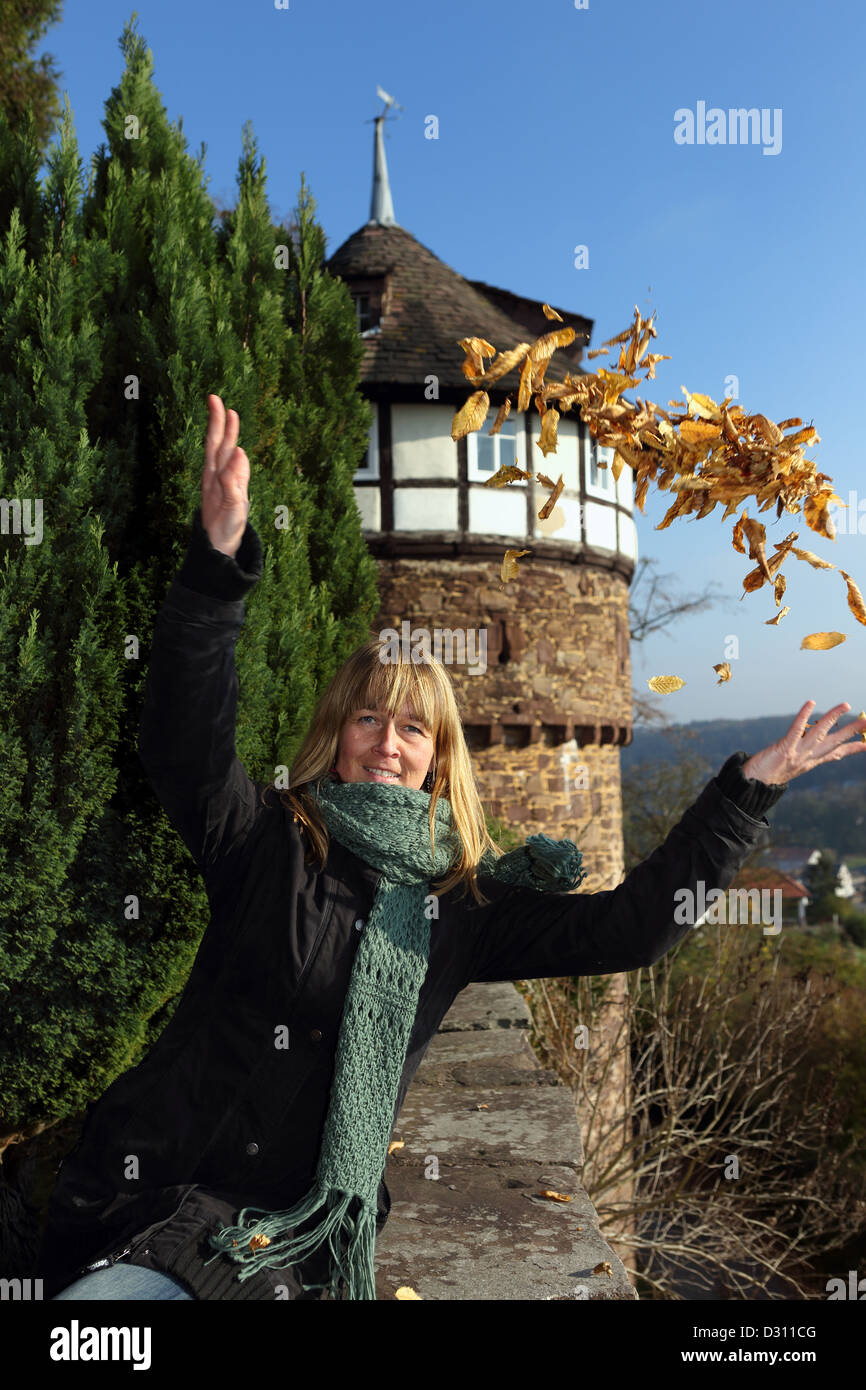 Trendelburg, Deutschland, verlässt Frau Herbst wirft vor dem Schloss in der Luft Trendelburg Stockfoto