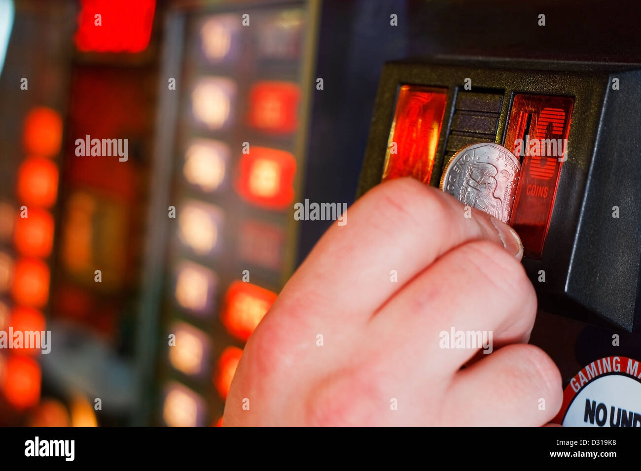 Spieler fügt Dollar in Slot-Maschine Stockfoto