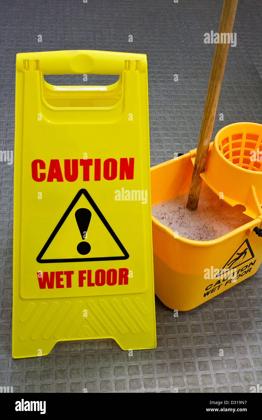 Vorsicht nassen Boden Schild mit Wischmopp und Eimer Stockfoto
