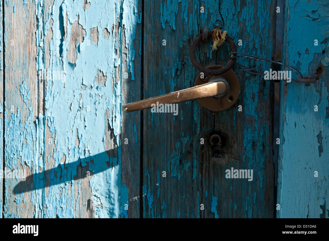 Eine alte bemalte Holztür mit Metallgriff und Krawatte Ring mit einer Schlaufe aus Draht angebracht, um Haken um zu halten, schließen. Stockfoto