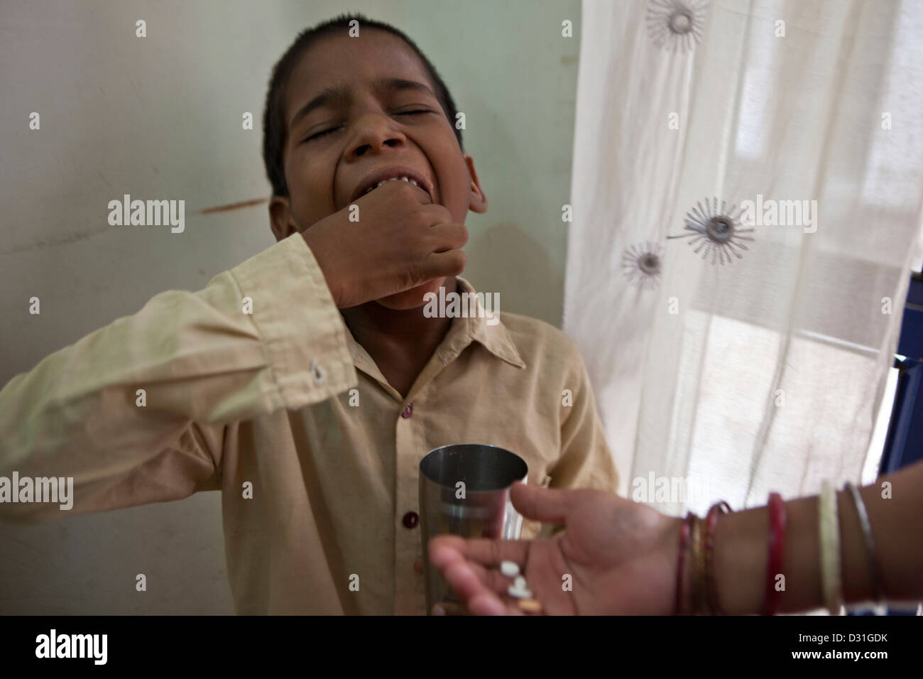 8 Jahre alten indischen jungen erhält seine täglichen Medikamente Tabletten für Tuberkulose (TB) die verzichtet wird, sind für ihn. Delhi, Indien Stockfoto