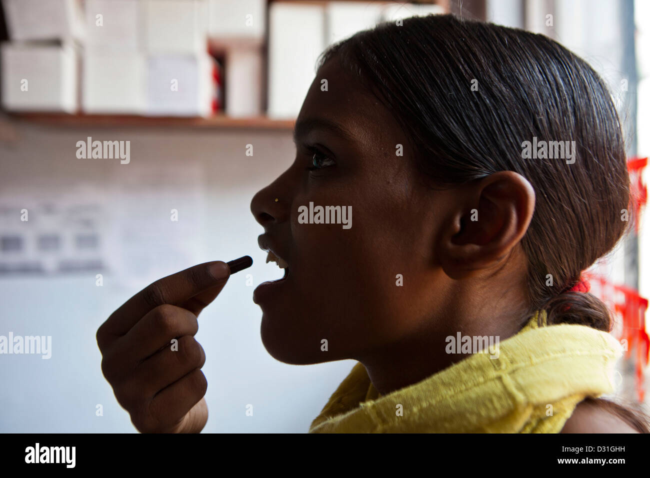 Ein Patient schluckt Tuberkulose (TB) Medikamente in einer Gesundheitsversorgung Klinik in Delhi, Indien. Stockfoto