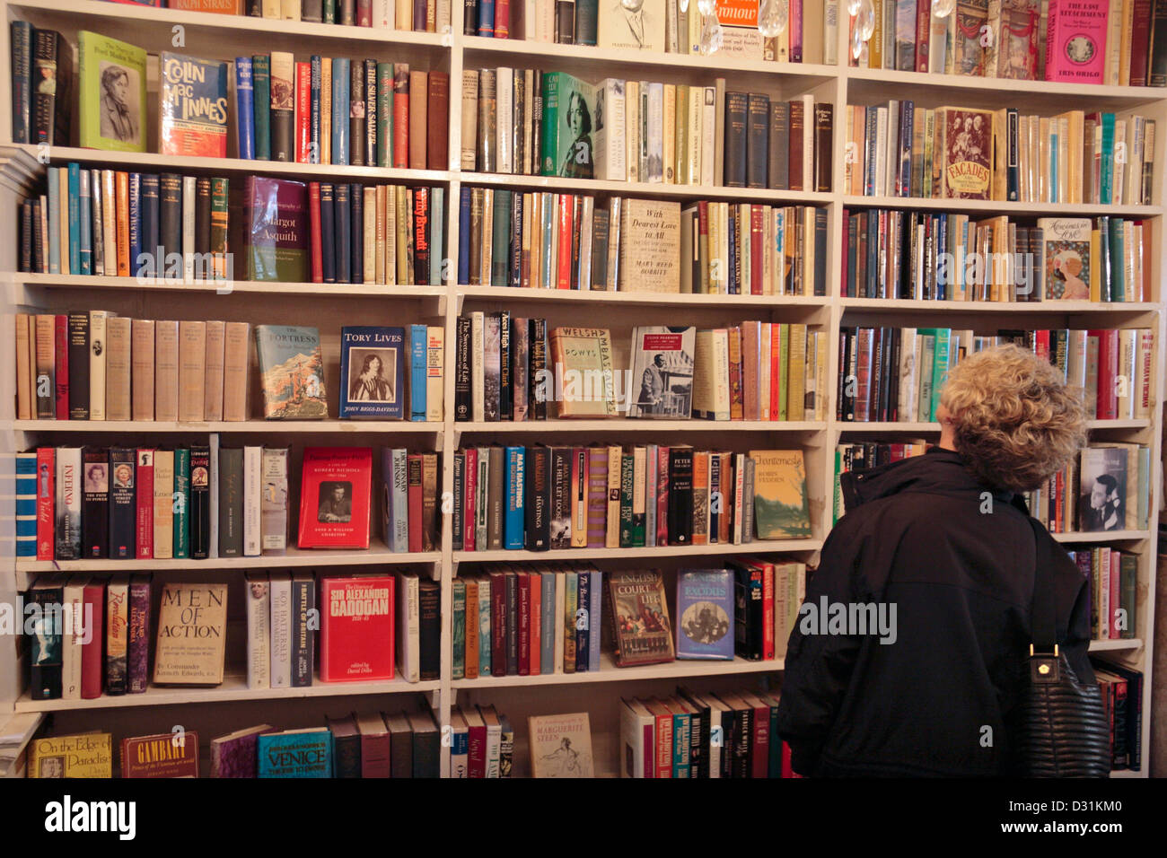 Eine Frau, die Durchsicht der Bücher in der Buchhandlung G. Heywood Hill Ltd, 10 Curzon Street, London, UK. Stockfoto