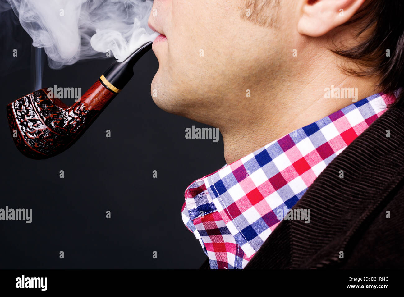 Nahaufnahme eines Mannes raucht eine Pfeife auf grauem Hintergrund isoliert Stockfoto