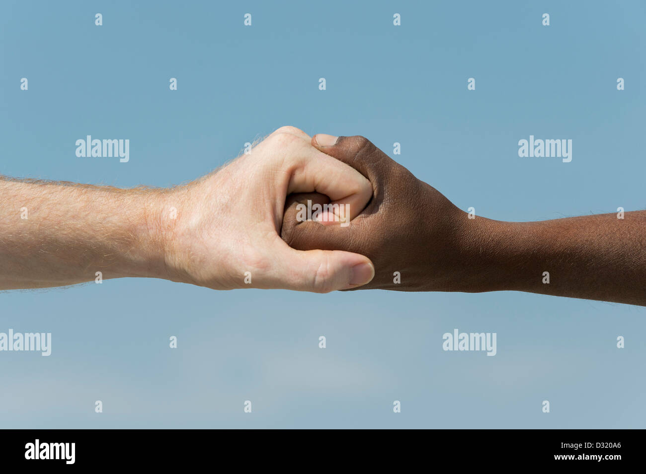 Indische und englische Hände. Westliche und Östliche Hand schütteln vor blauem Himmel. Indien. Eine Menschheit Konzept. Stockfoto