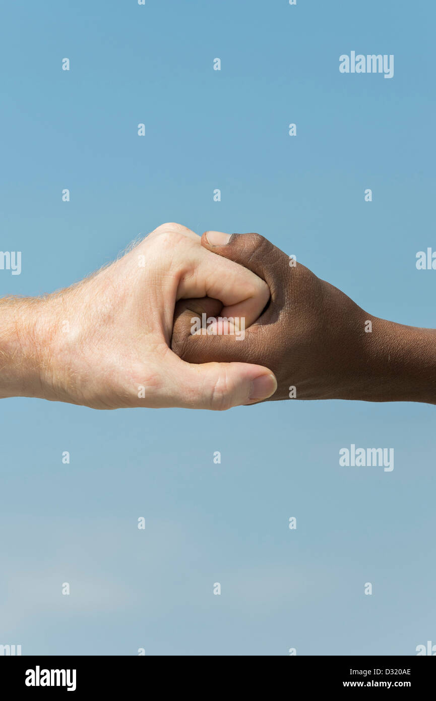 Indische und englische Hände. Westliche und Östliche Hand schütteln vor blauem Himmel. Indien. Eine Menschheit Konzept. Stockfoto