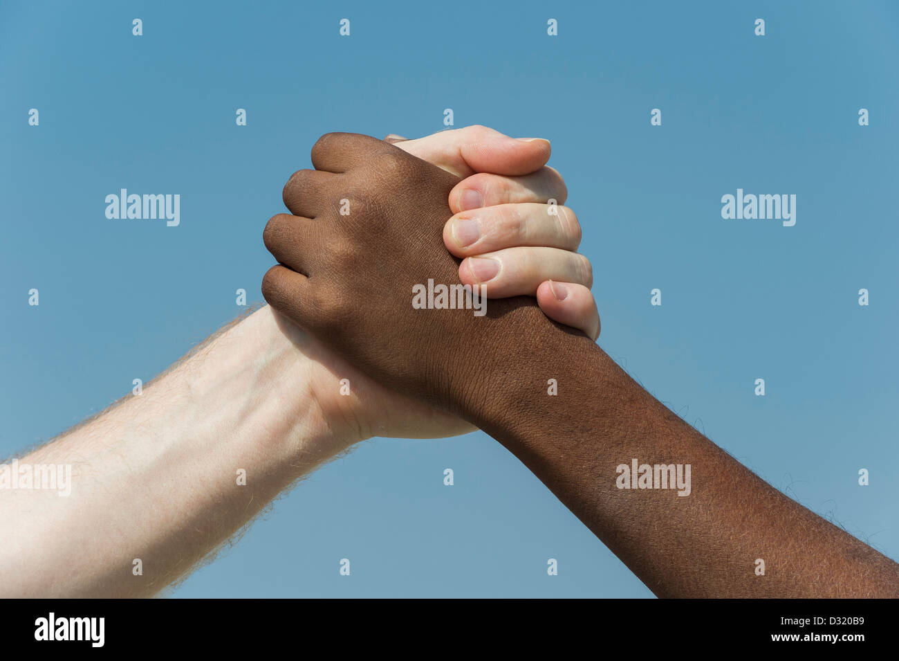 Indische und englische Hände. Westliche und Östliche Hand schütteln vor blauem Himmel. Indien. Eine Menschheit Konzept. Stockfoto