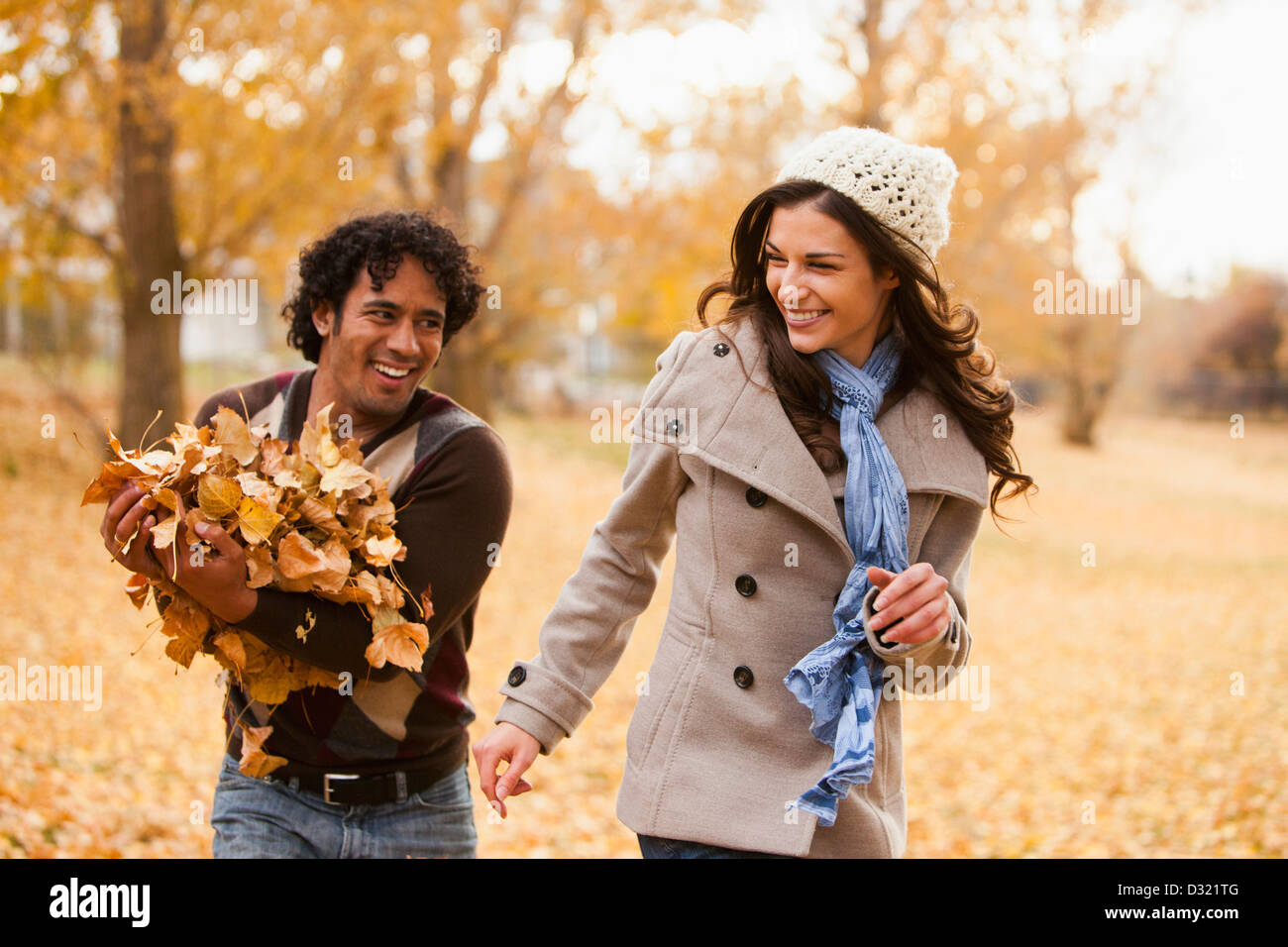 Paar spielen im Herbstlaub Stockfoto