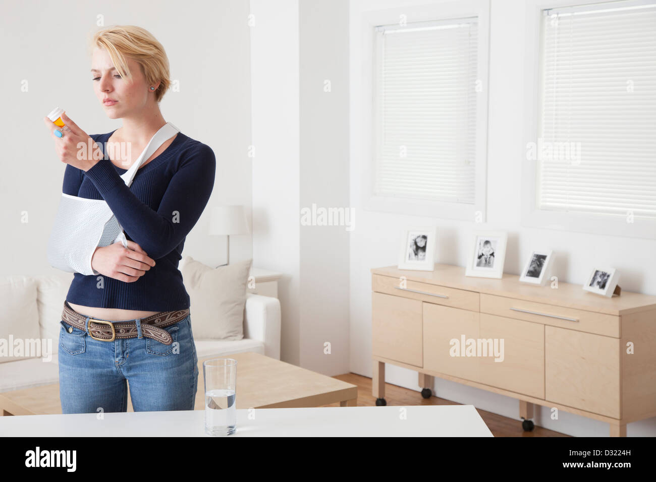 Kaukasische Frau mit gebrochenen Arm Pille Flasche lesen Stockfoto