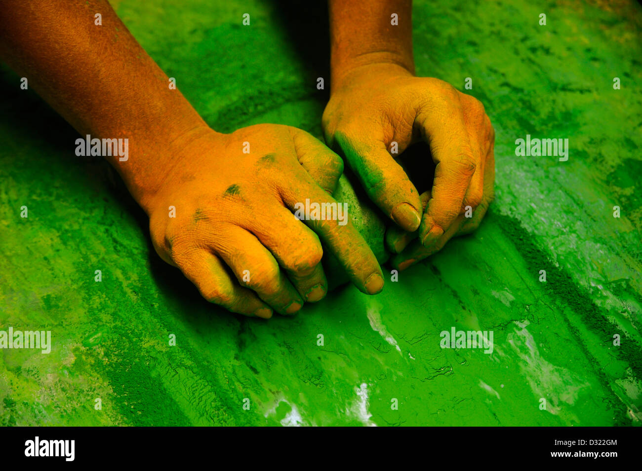 Ein Handwerker gelb gefärbten Hände Schleifen grünen Farbstoff für den Einsatz in Bagan Lacquerware Stockfoto