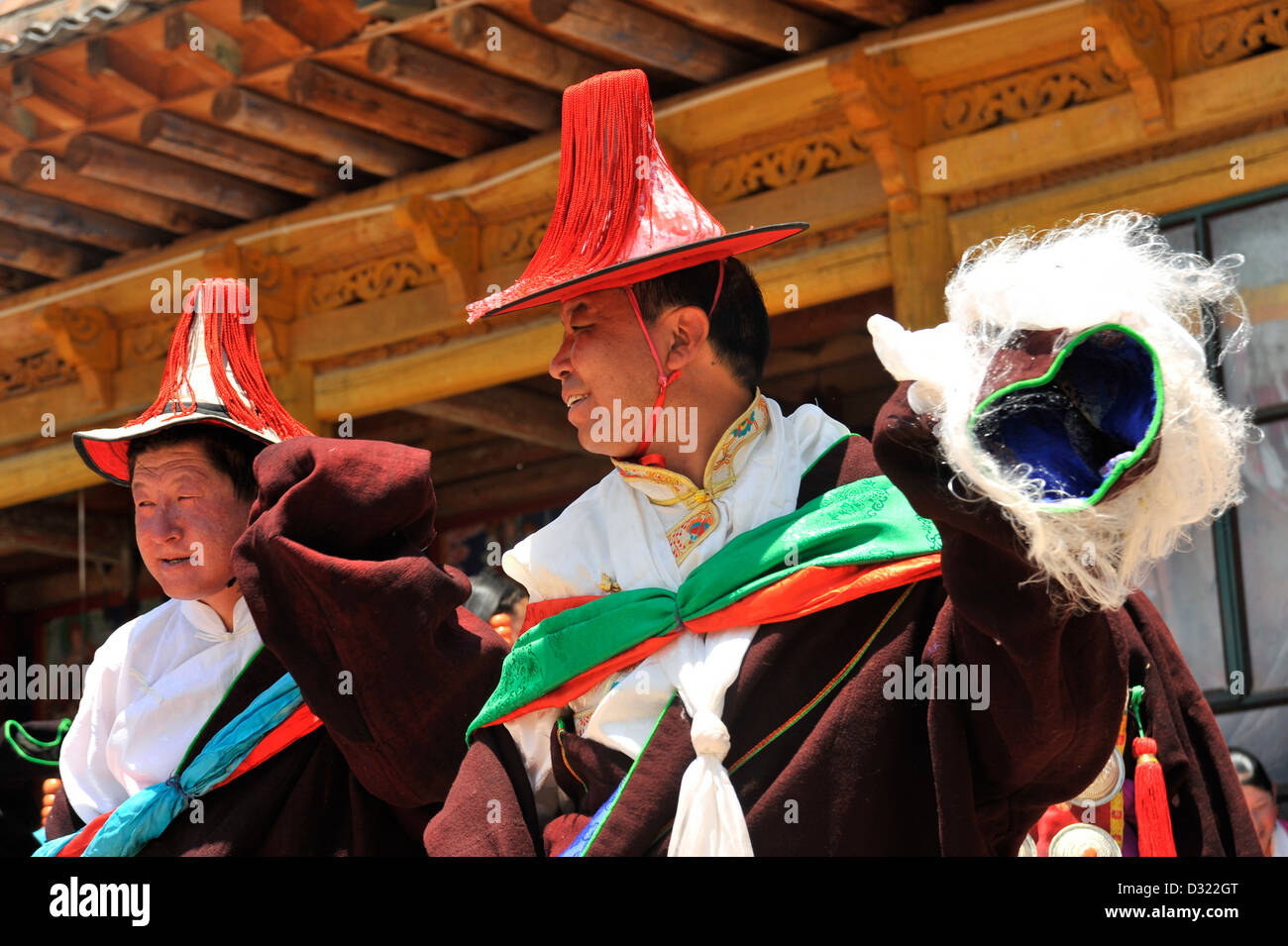 Tibetische Männer tanzen in einer Prozession auf dem Tongren Schamane Festival Stockfoto