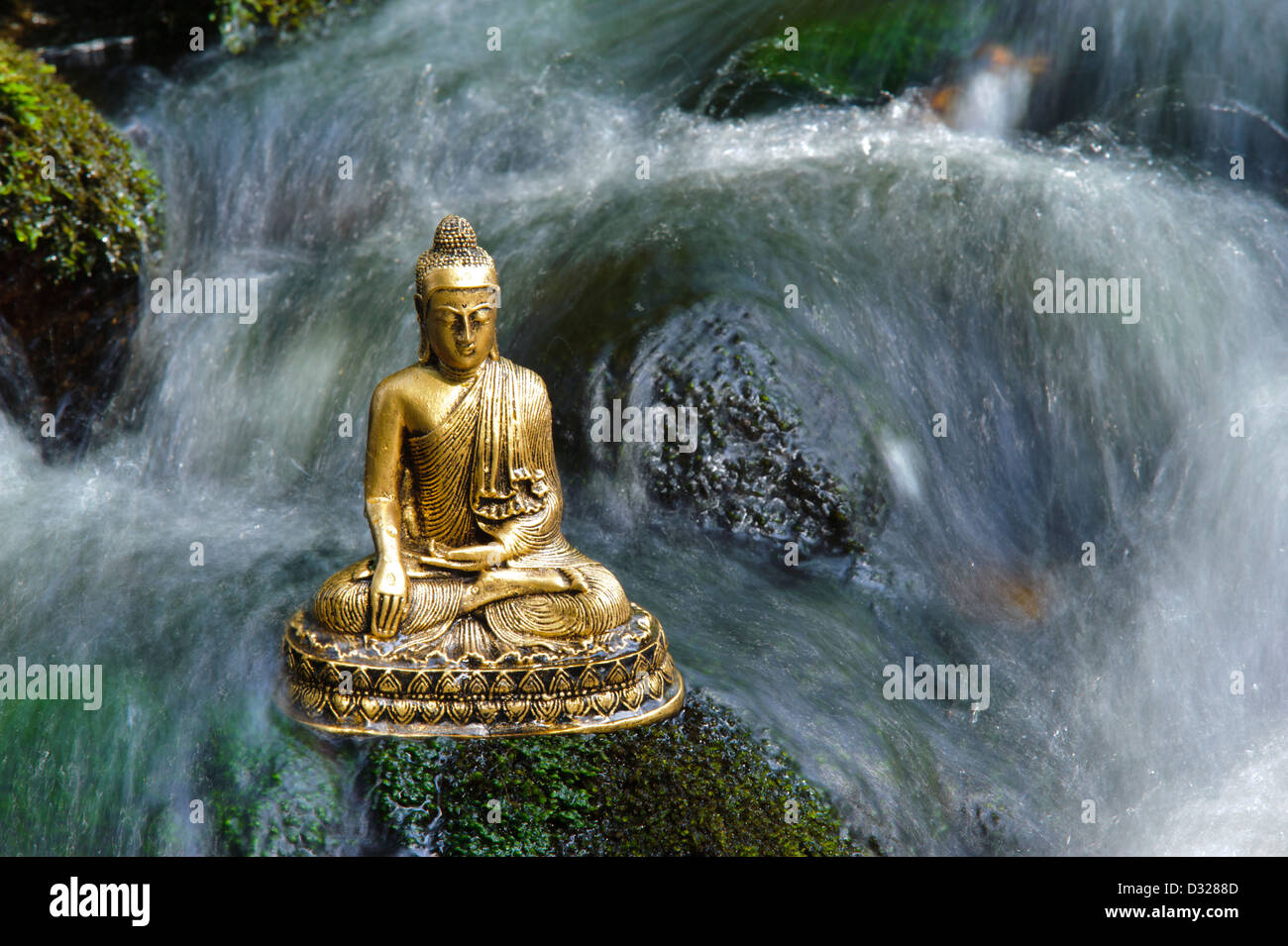 Buddhafigur sitzt im Wasserfall Stockfoto
