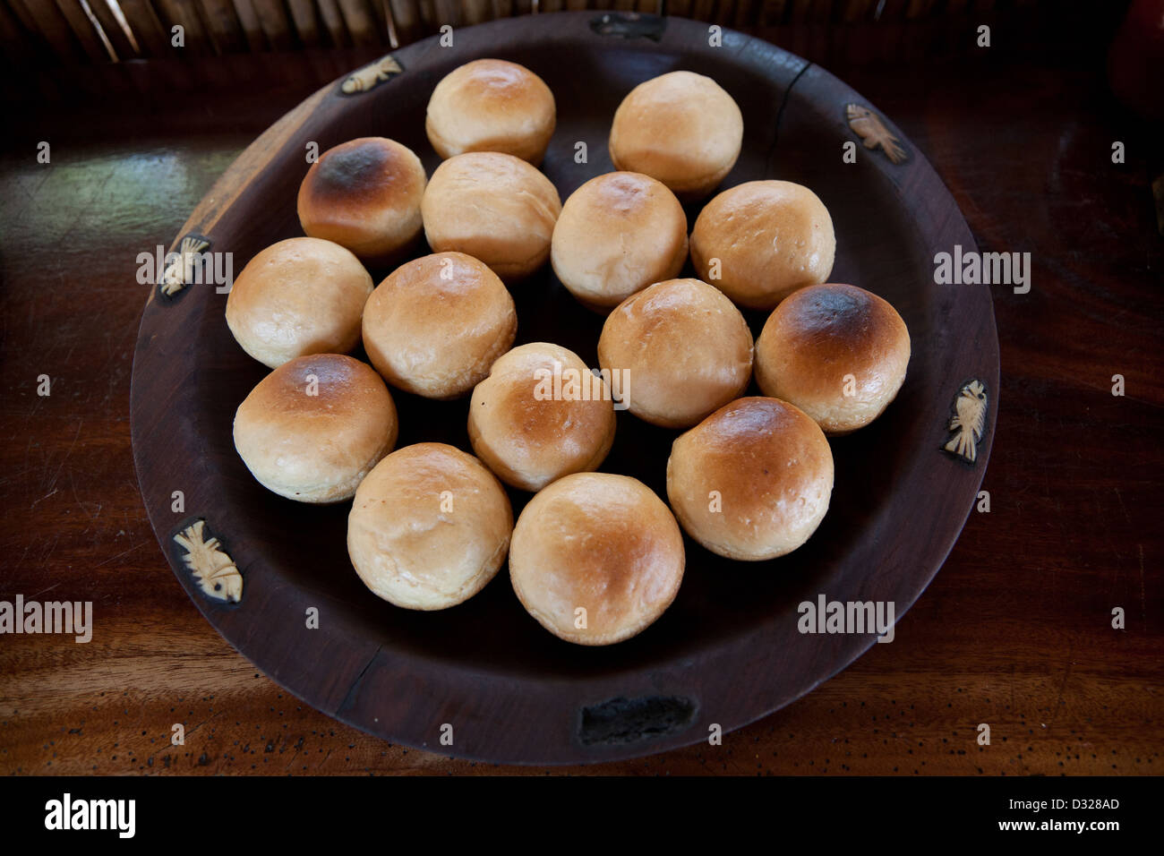 Frische Brötchen in einer Holzschale mit Fisch auf den Kanten carven Stockfoto