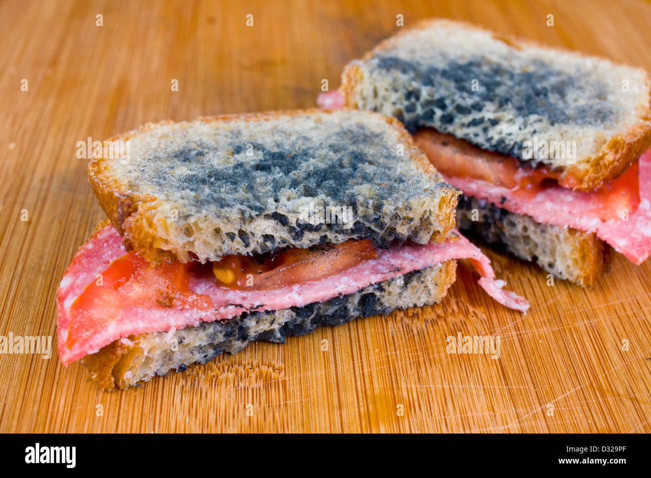 schimmelige Sandwich mit Salami, Tomaten auf einem Schneidebrett Stockfoto