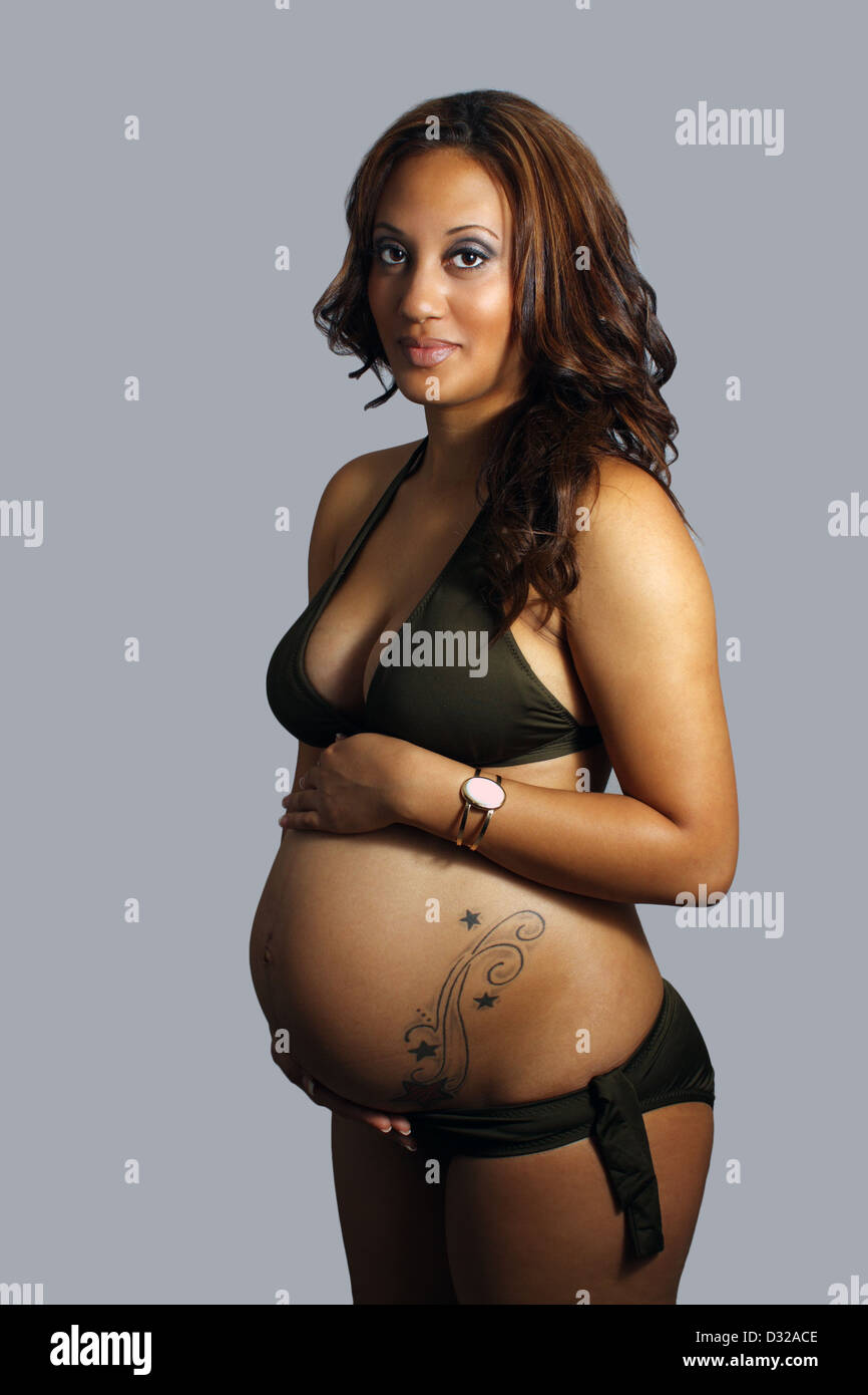 Bikini bekleideten Frau im achten Monat schwanger mit Tattoo  Stockfotografie - Alamy