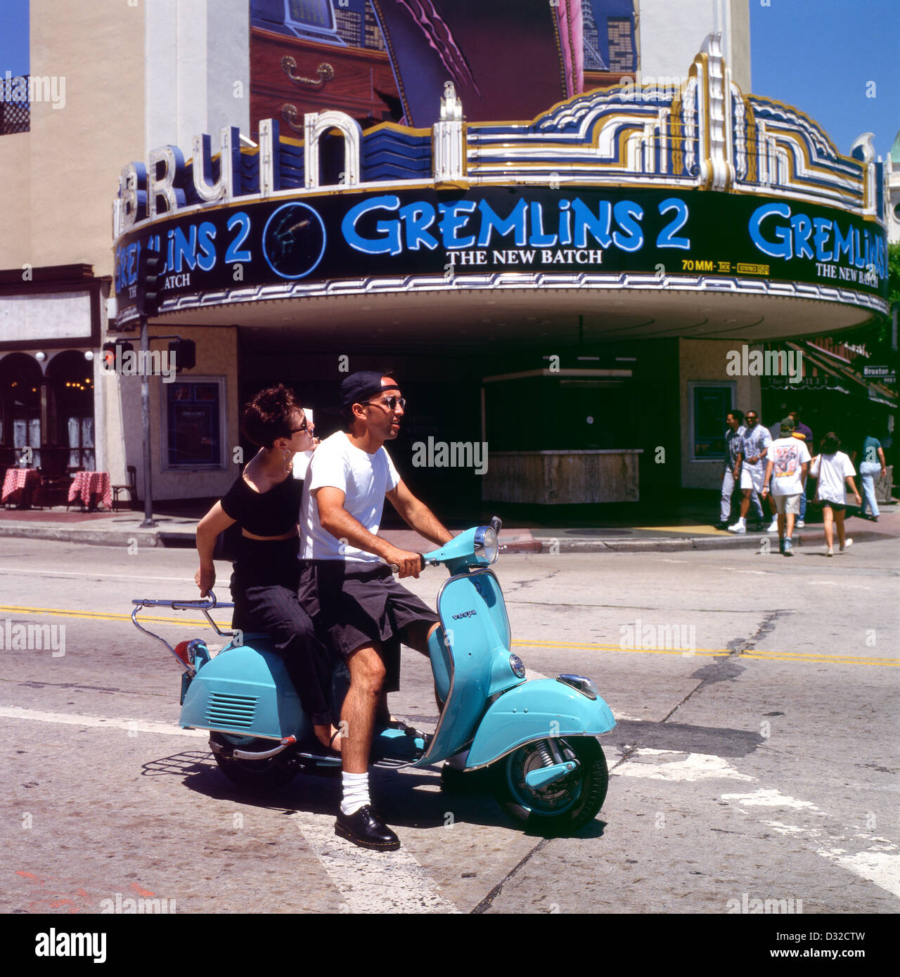 Paar auf einem Motorroller fahren vorbei Gremlins 2 Film im Bruin Westwood Village Theater Los Angeles LA California in 1989 1990 US USA KATHY DEWITT Stockfoto