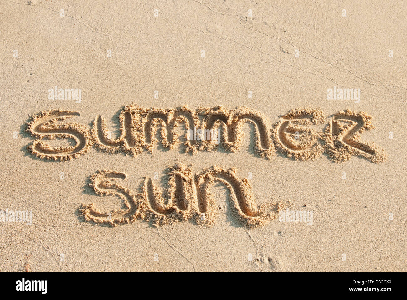 Sommersonne, geschrieben in den Sand am Strand Stockfoto