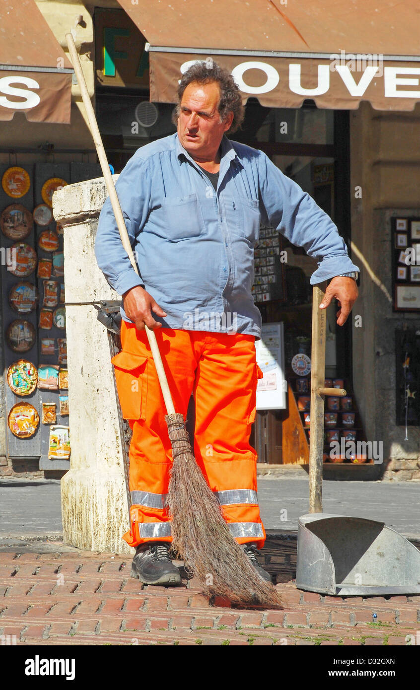 Porträt einer Straße Reiniger mit Besen & orange Hose Plaza Il Campo in Siena, Italien Stockfoto