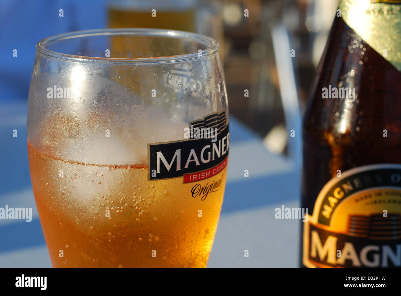 kalte erfrischende alkoholisches Getränk, das auf einem weißen Bar im freien Tisch in einem Ferienort in der heißen Sonne in Kondensation Glas abgedeckt Stockfoto