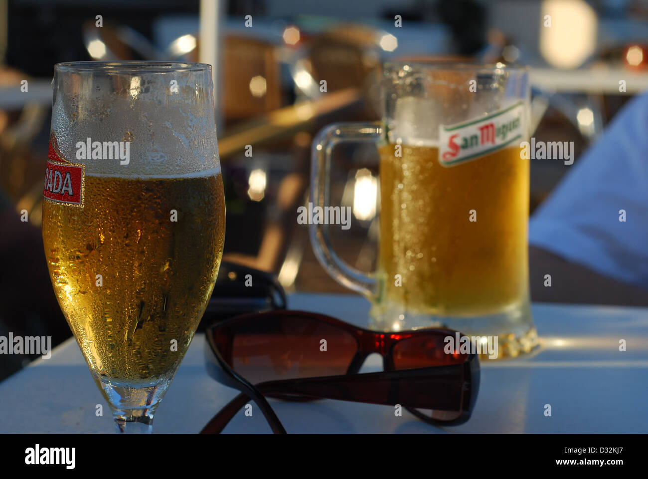 Zwei kalte erfrischende alkoholische Getränke auf einem weißen bar Tisch in einem Ferienort in der heißen Sonne im Freien mit Kondenswasser bedeckt Stockfoto