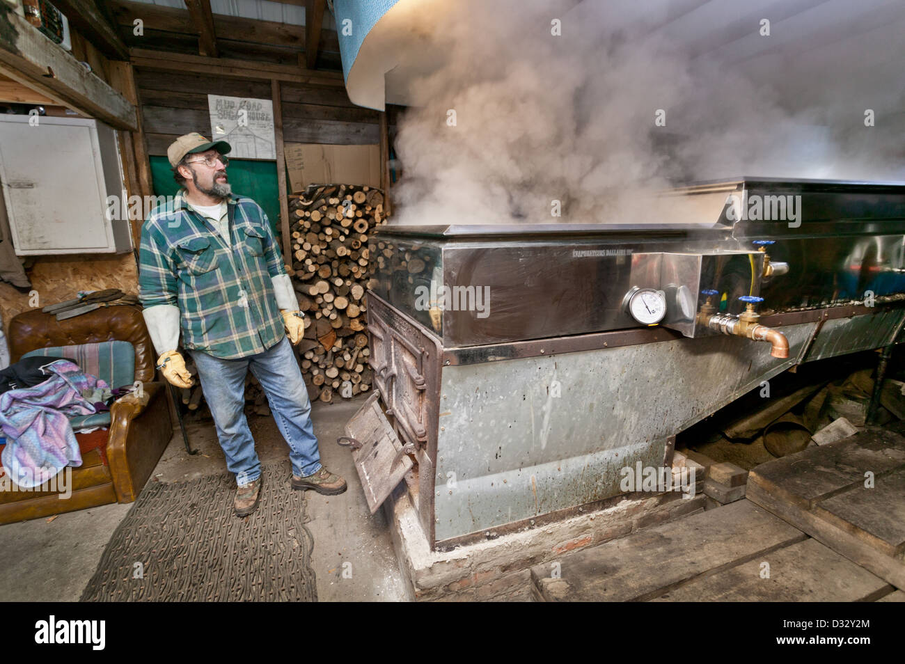 Ahornsirup-Hersteller bewundert Dampf steigt aus Verdampfer während des Kochens Sap, Adirondacks, New York State Stockfoto