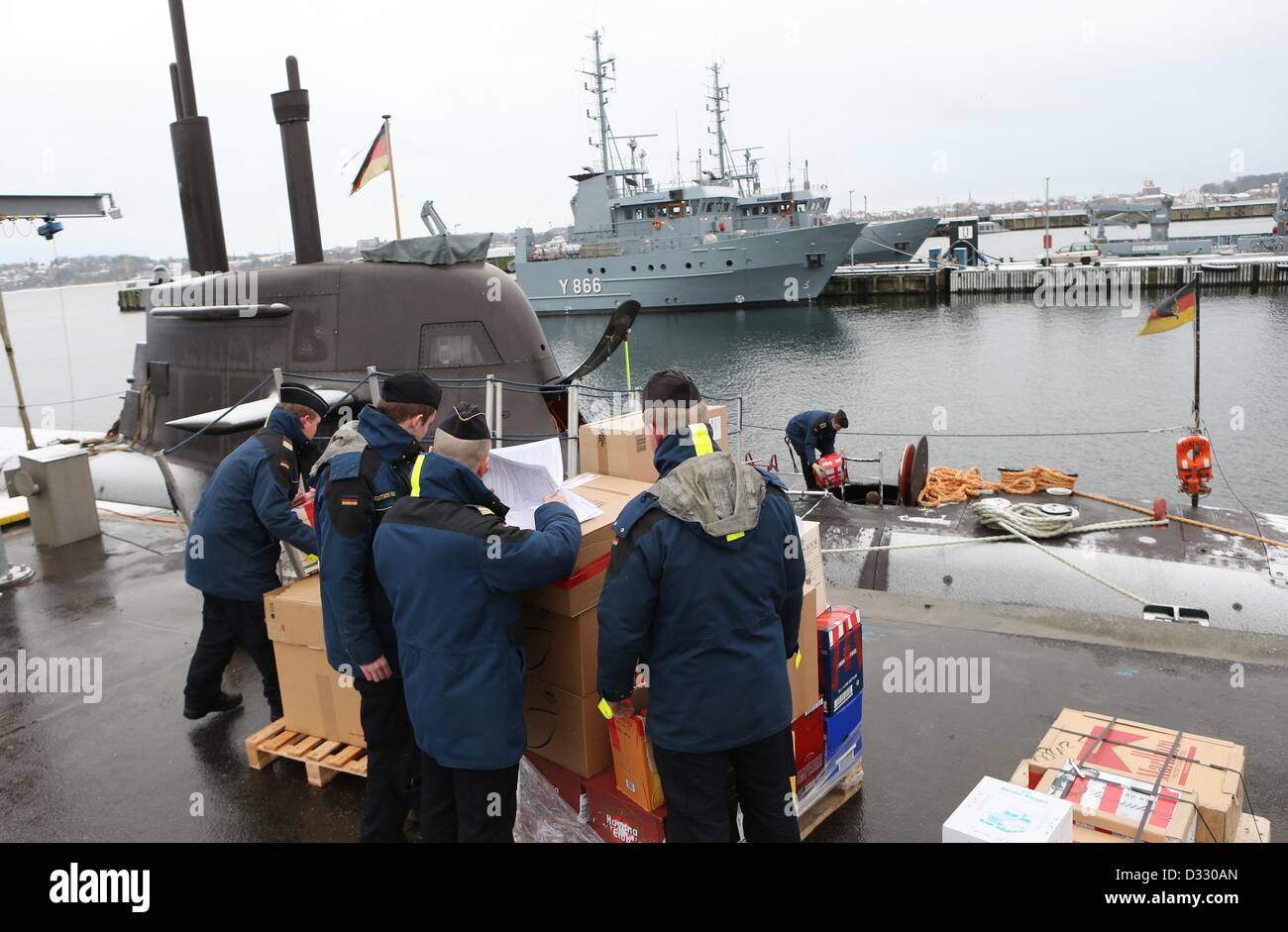 Eckernfoerde, Deutschland. 7. Februar 2013. Crew-Mitglieder tragen Versorgung an Bord von u-Boot U 32 am Marinehafen in Eckernfoerde, Deutschland, 7. Februar 2013. Das u-Boot wird in der internationalen Übung "Westlant Einsatz" an der Ostküste der USA am 10. Februar 2013 teilnehmen. Ein Höhepunkt des vier Monate lange Übung einen simulierten Kampf zwischen einem u-Boot und ein amerikanischer Flugzeugträger-Flotte werden. Foto: Christian Charisius/Dpa/Alamy Live News Stockfoto