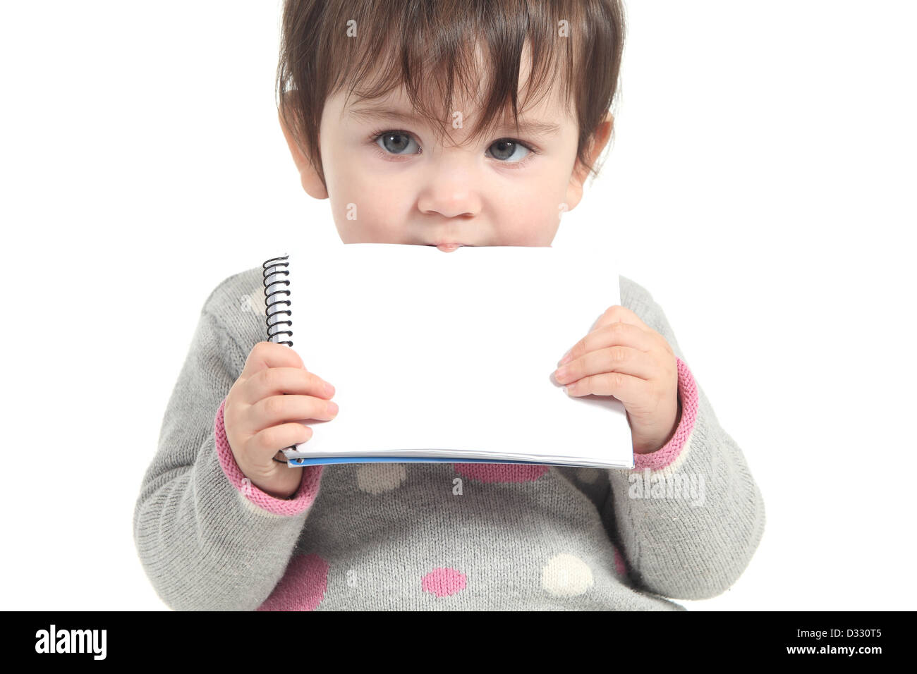 Baby beißt eine leere Arbeitsmappe auf einem weißen Hintergrund isoliert Stockfoto