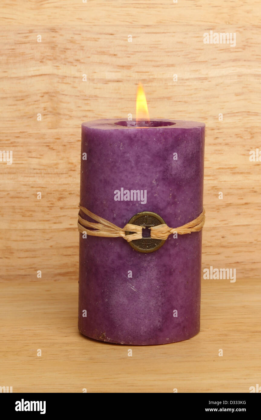 Brennende lila Feng Shui Kerze Holz Hintergrund Stockfoto