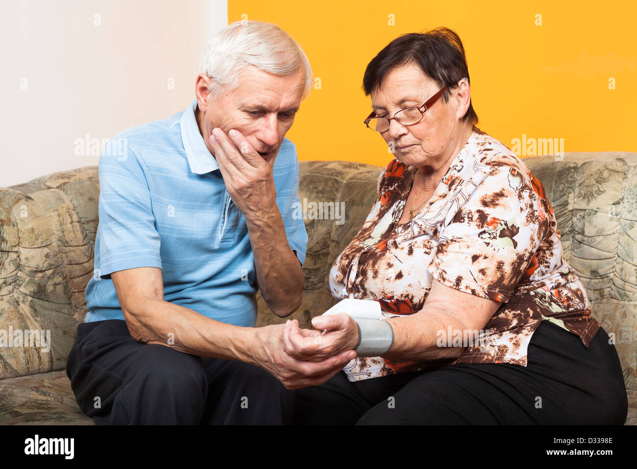Zwei besorgt Senioren Blutdruck zu Hause prüfen. Stockfoto