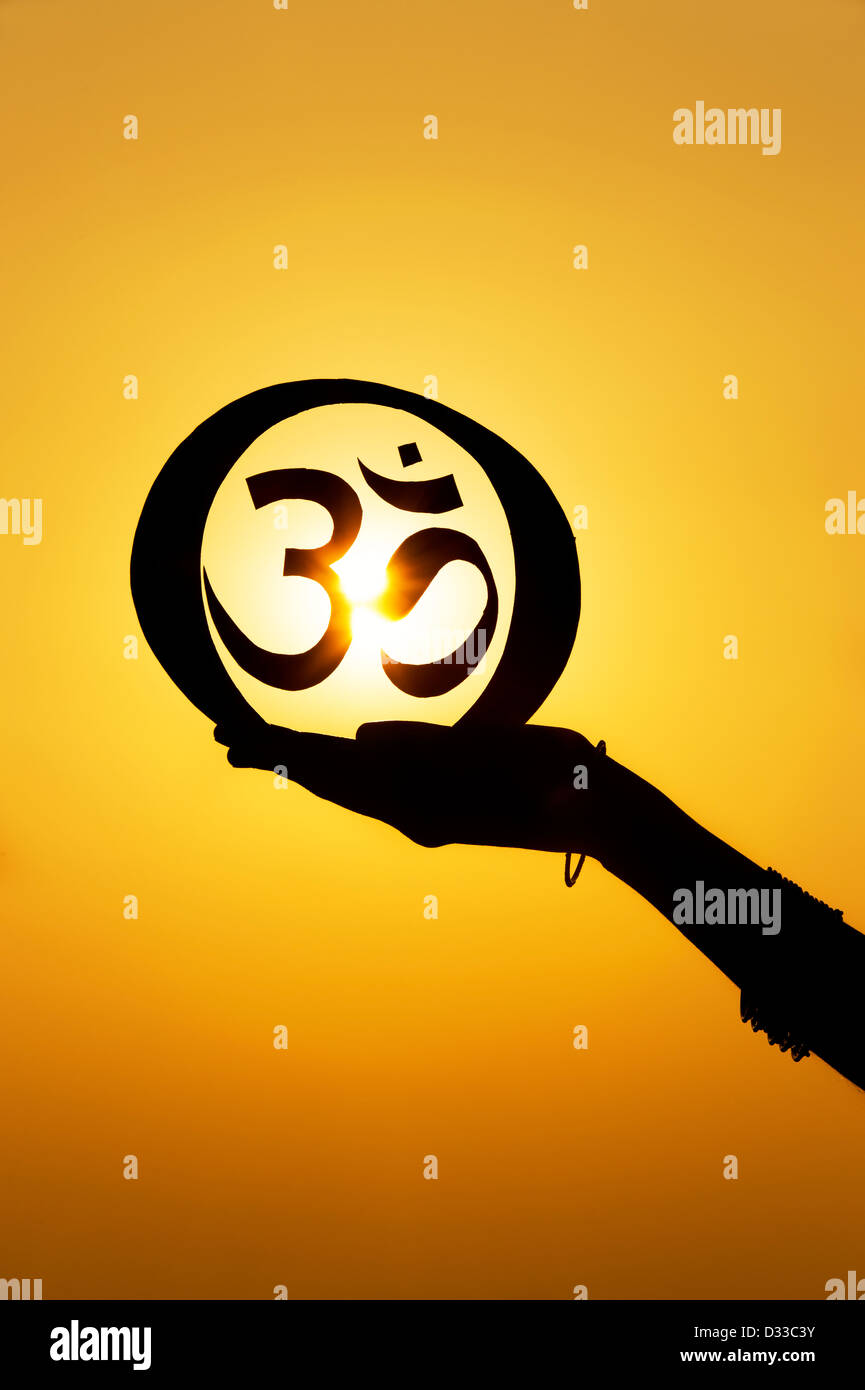 Hand, die hinduistischen OM / AUM symbol bei Sonnenuntergang. Indien. Silhouette Stockfoto