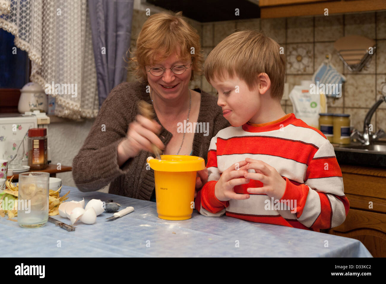 eine Mutter und ihr junger Sohn gemeinsam eine Mahlzeit zuzubereiten Stockfoto