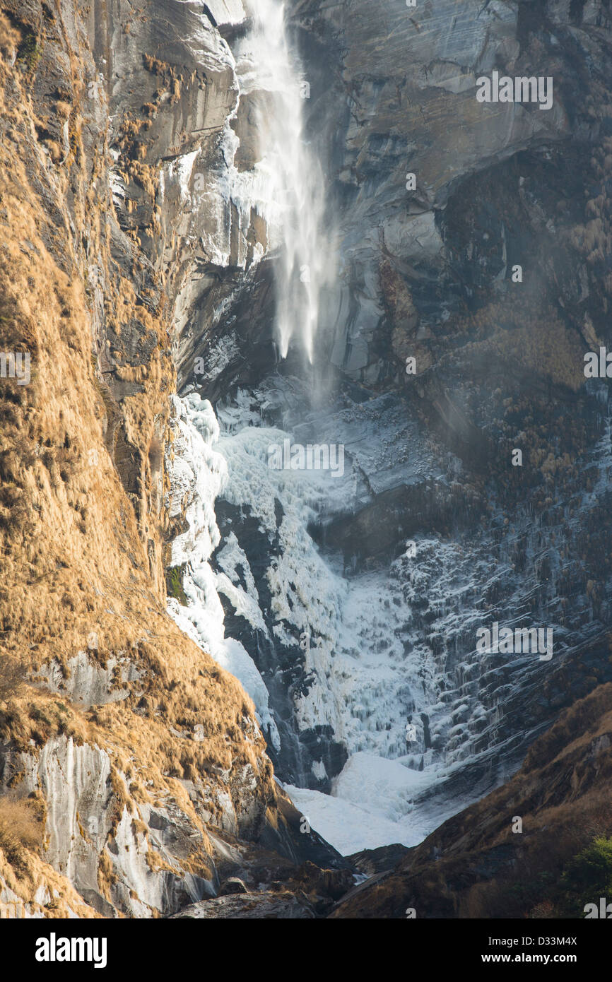Ein teilweise gefrorenen Wasserfall an den unteren Hängen des Machapuchare oder der Heiligen, Fish Tail Peak im Annapurna Himalaya, Nepal. Stockfoto