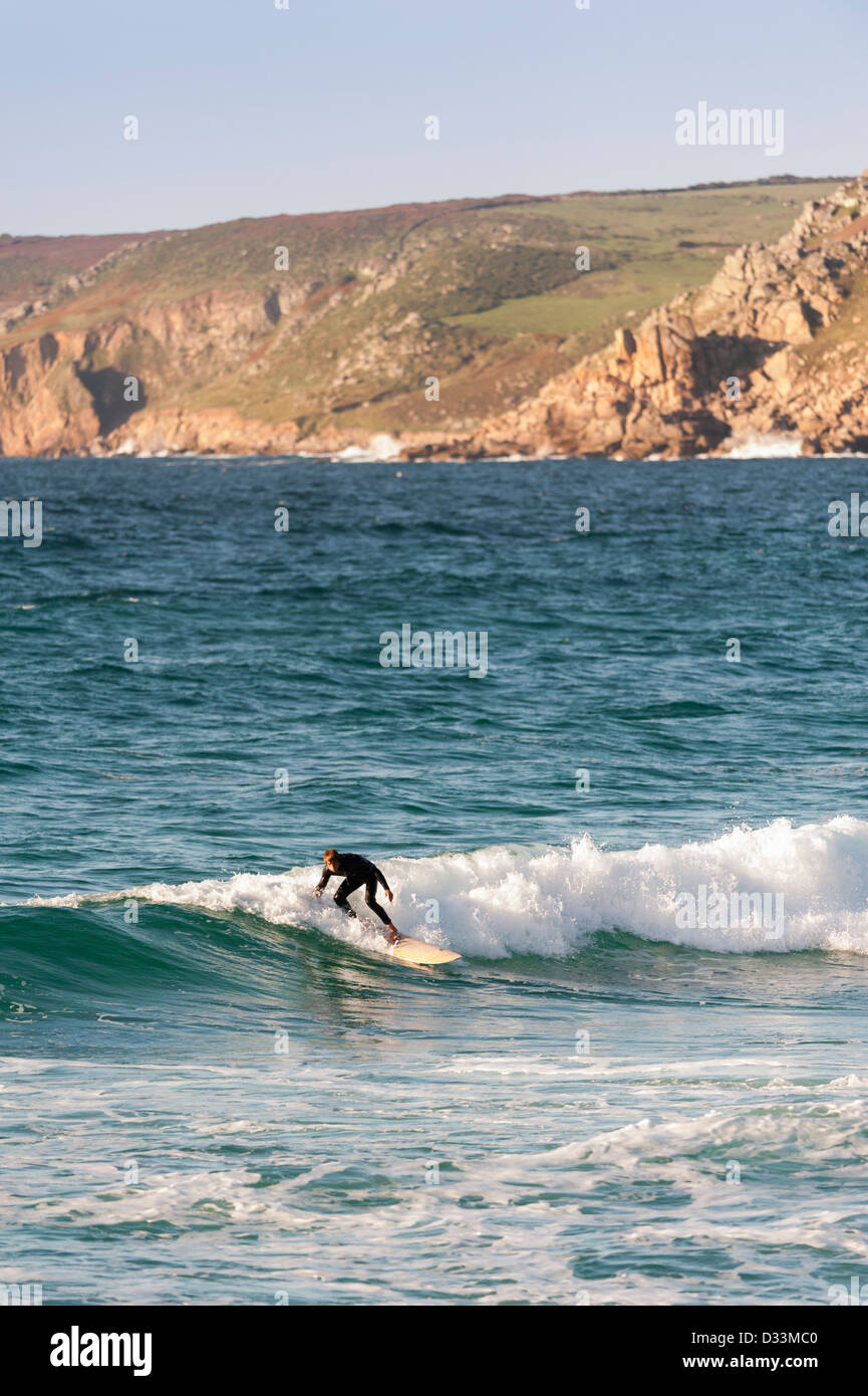 Ein einsamer Surfer auf einer Welle an Sennen in Cornwall, England, UK Stockfoto