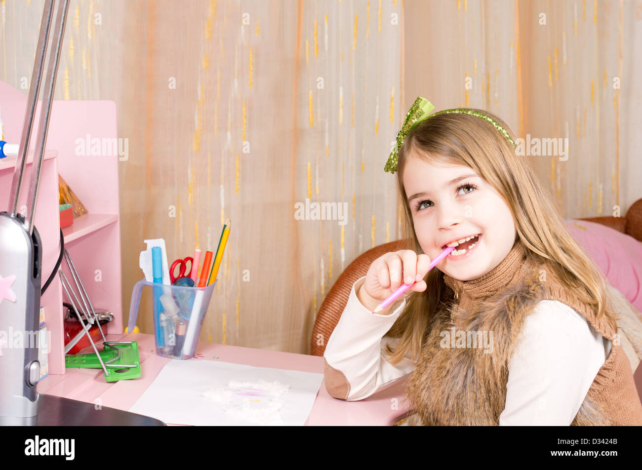 Ziemlich glücklich kleine Mädchen an ihrem rosa Schreibtisch kauen ihr Bleistift blickte auf die Decke Tagträumen mit einem schönen Lächeln auf ihrem Gesicht sitzt. Stockfoto