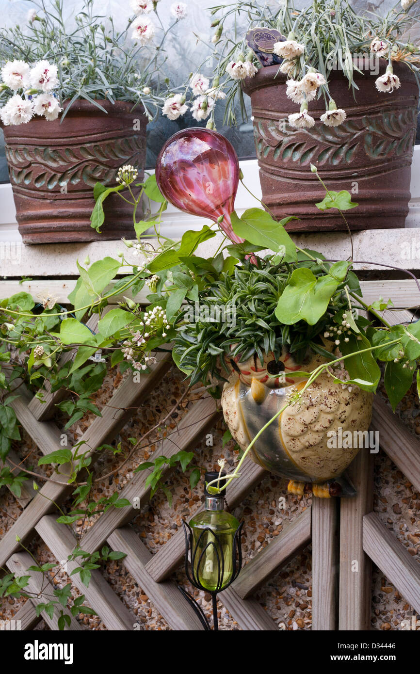 Gartendekor und Topfpflanzen an der Wand. Stockfoto