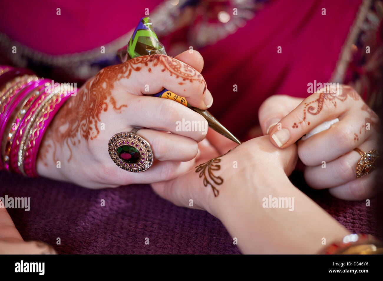 Künstler, die Anwendung von Henna auf die Palme der Hand einer Frau Stockfoto