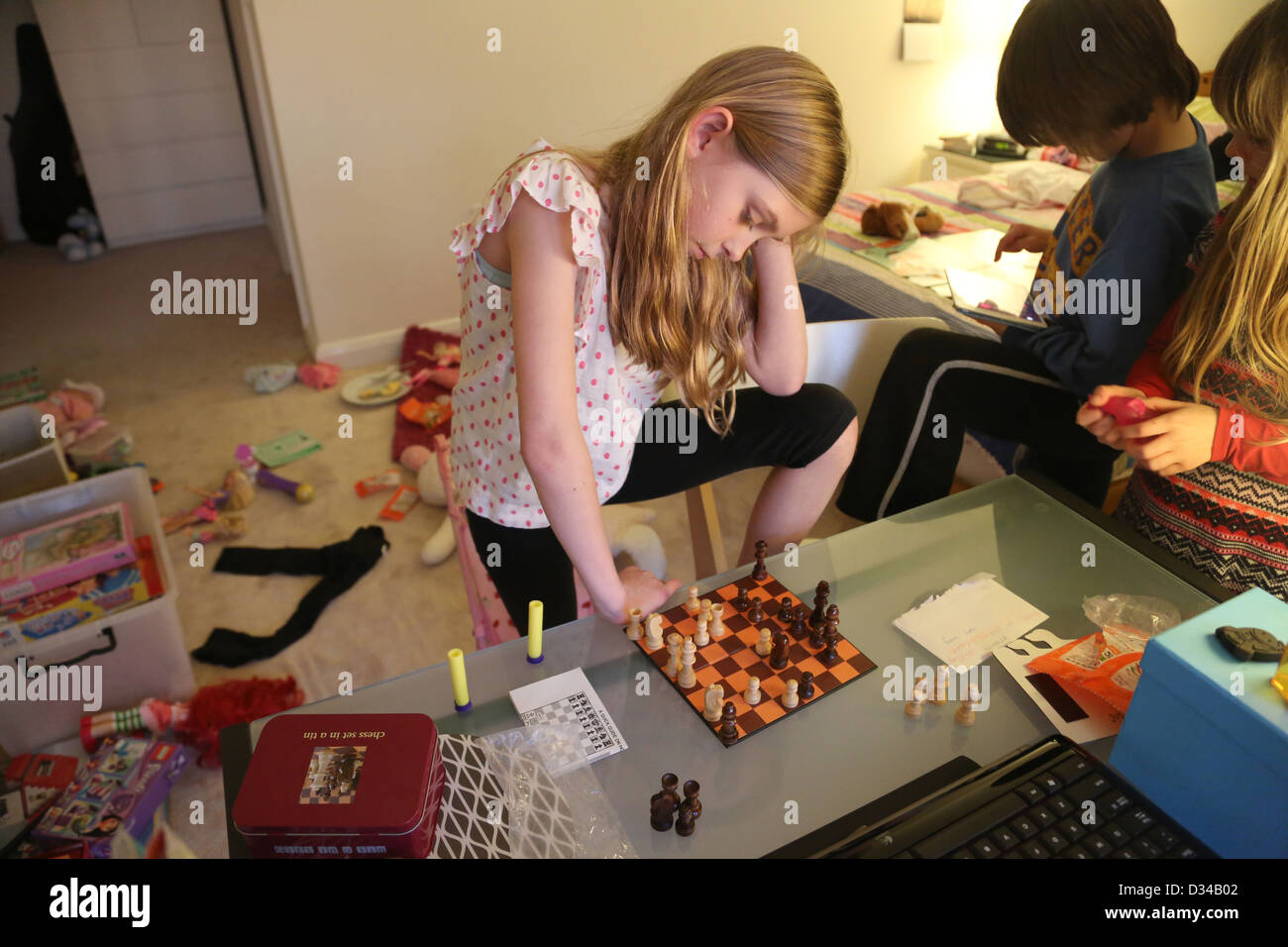 Mädchen spielen Schach In ihrem Schlafzimmer Boy mit iPad Mini England Stockfoto