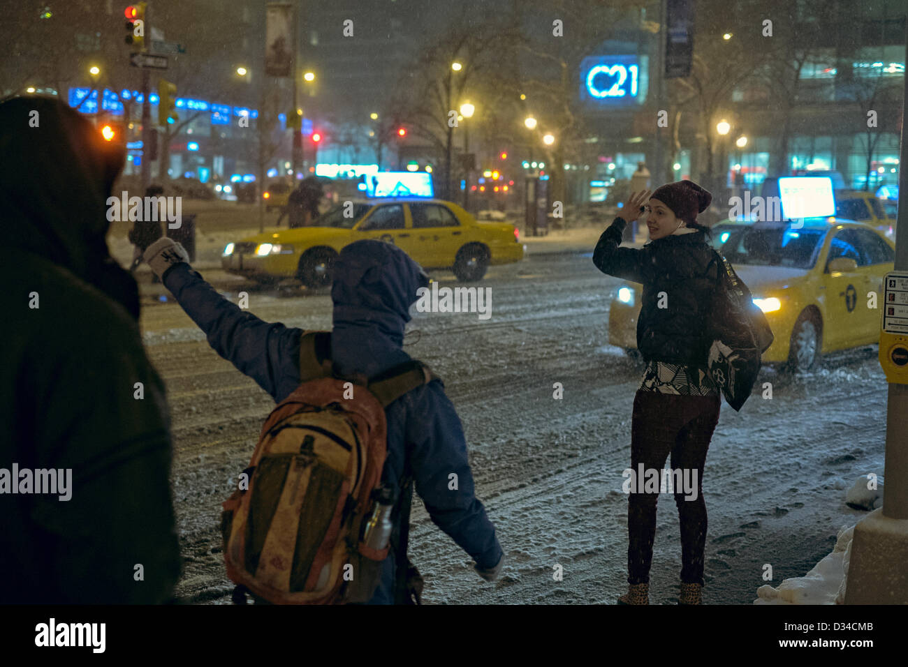 New York, USA. 8. Februar 2013. Eine junge Frau versucht, ein Taxi an der Columbus Avenue als schweren Schneedecken New York City zu kommen. Bildnachweis: Joseph Reid / Alamy Live News Stockfoto