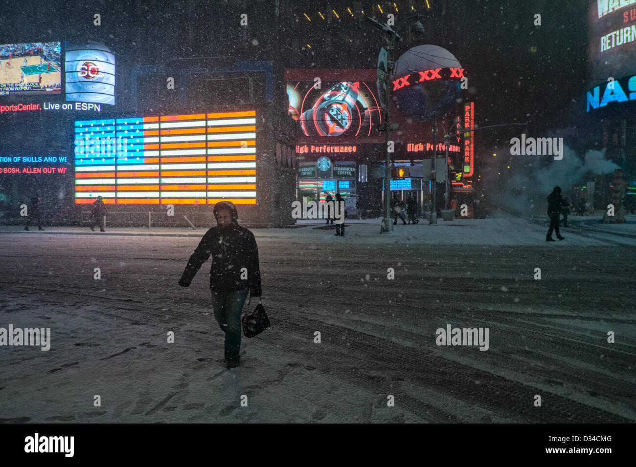 New York, USA. 8. Februar 2013. Eine Frau kreuzt 7th Avenue nahe dem Times Square, wie Schnee von einem Wintersturm fällt, die voraussichtlich um bis zu zwei Füße Schnee auf Teile der nordöstlichen Vereinigten Staaten zu bringen. Bildnachweis: Joseph Reid / Alamy Live News Stockfoto
